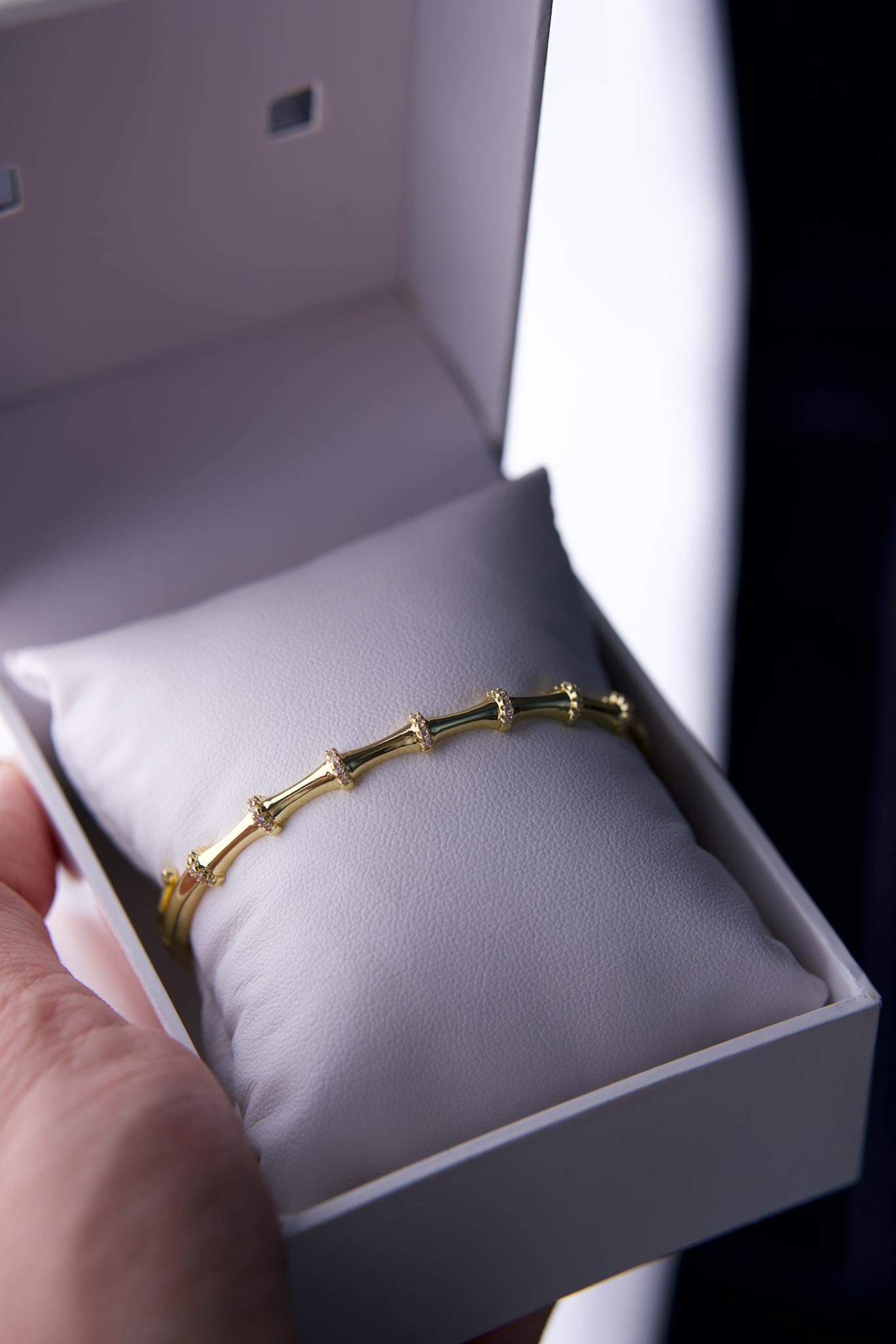 Close-up of a gold bracelet presented in a stylish white gift box, ideal for special occasions.
